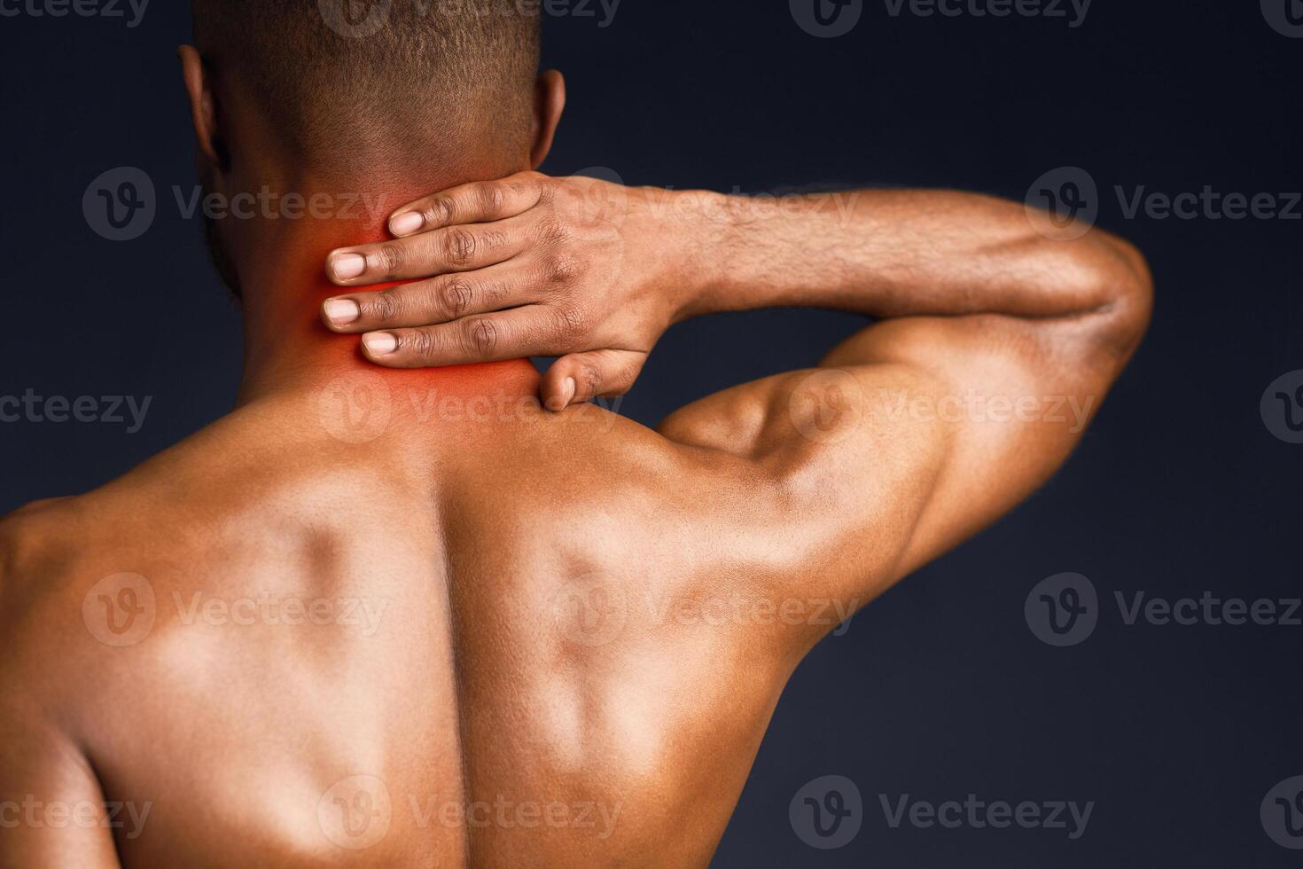 Back View. Shirtless black man suffering from pain in neck, symptom of cervical chondrosis, red spot, trauma photo