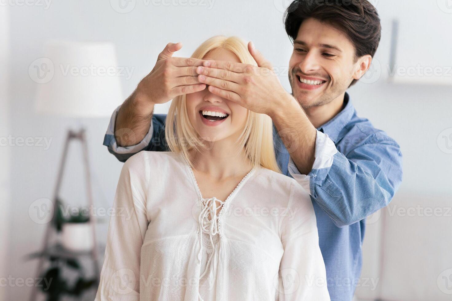 Dreams Come True Concept. Husband Covering Woman Eyes Indoor Before Showing Their New Home. photo