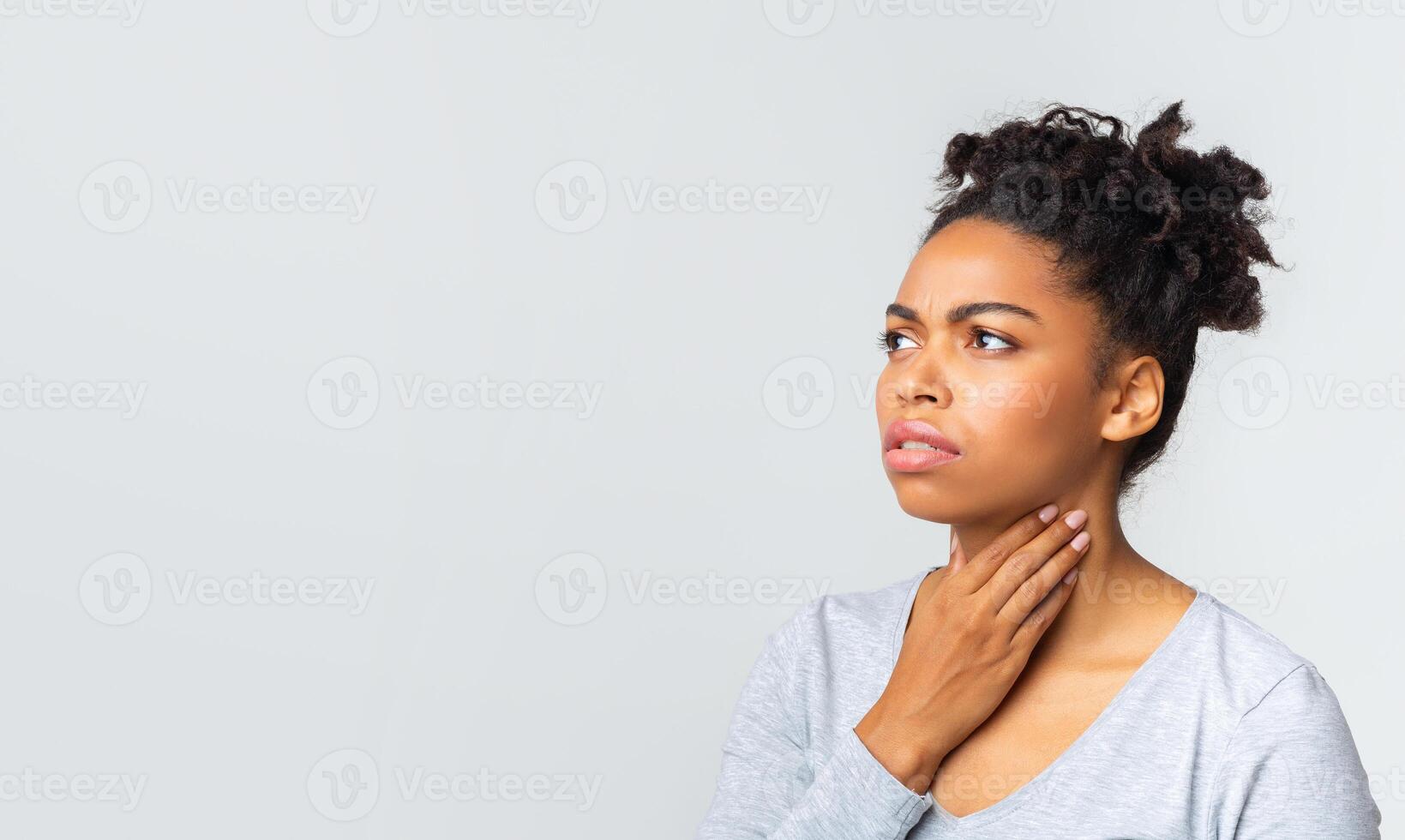 Upset afro woman having pain in her throat, touching neck, panorama with copy space photo