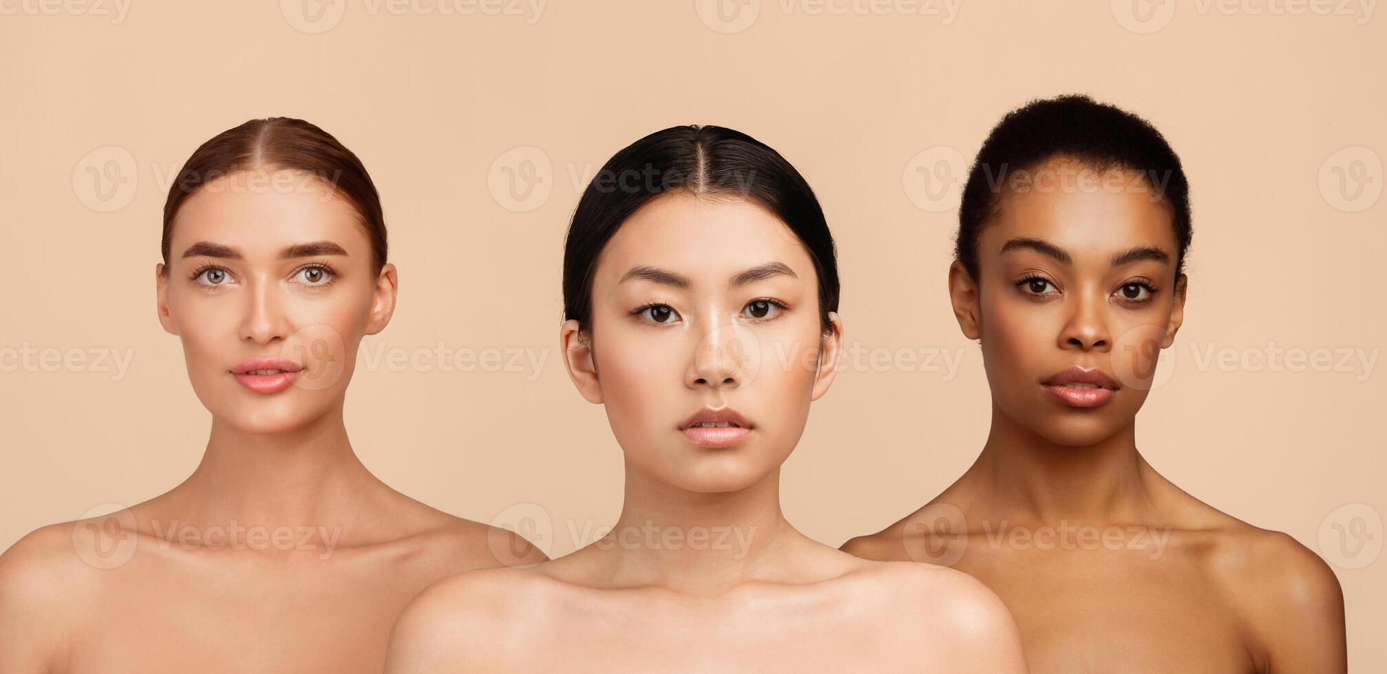 Portrait Of Three Sensual Diverse Girls Wrapped In Bath Towels Standing Posing In Studio Over Gray Background. Beauty Spa Concept. photo