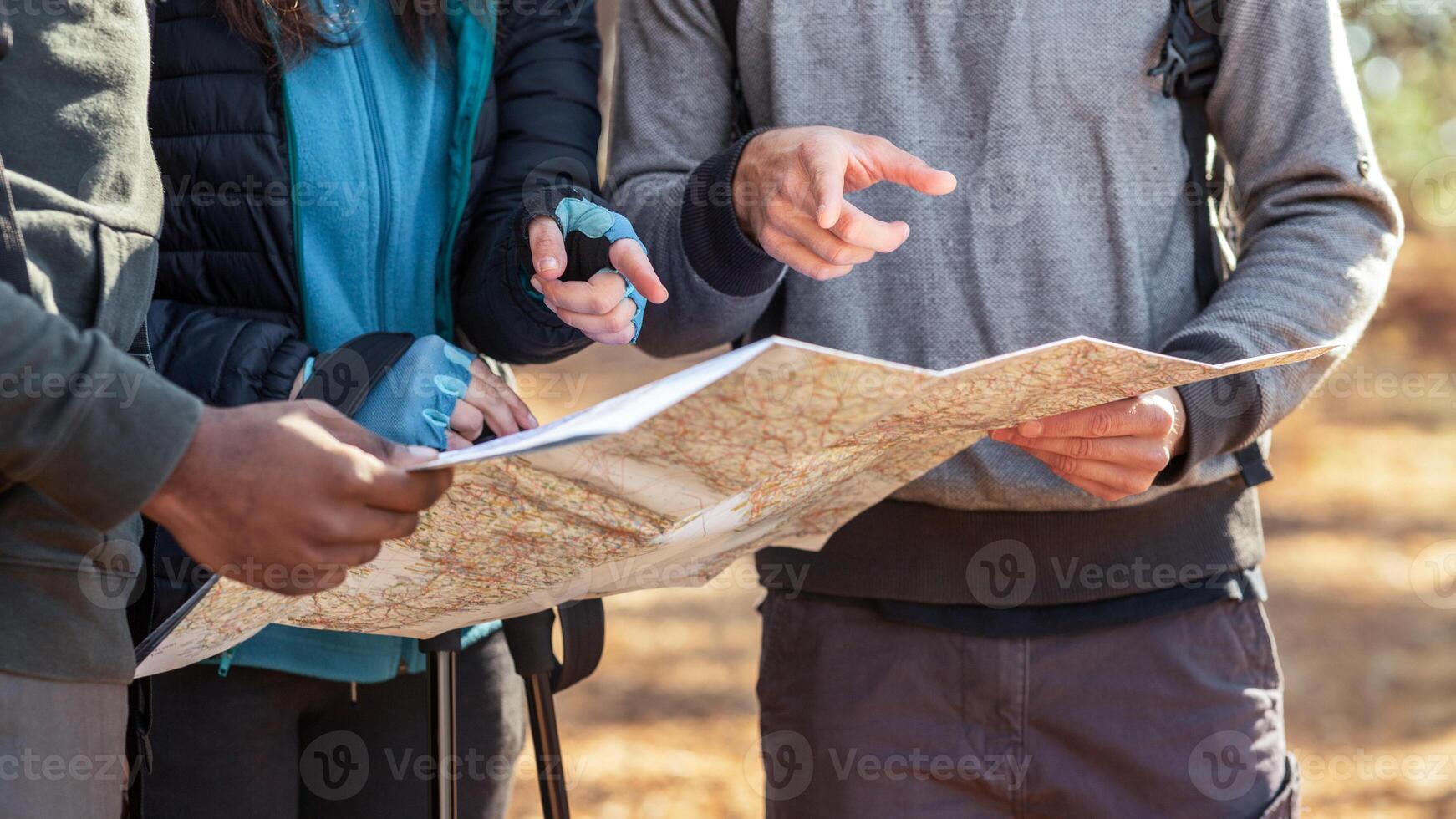 Cropped of lost travelers holding map, discussing location, got lost at forest photo