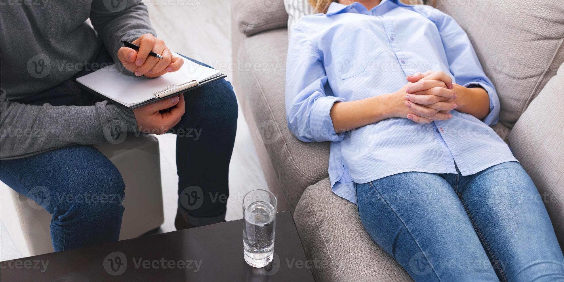 At psychotherapist. Depressed woman lying on sofa, consulting with psychologist at session photo