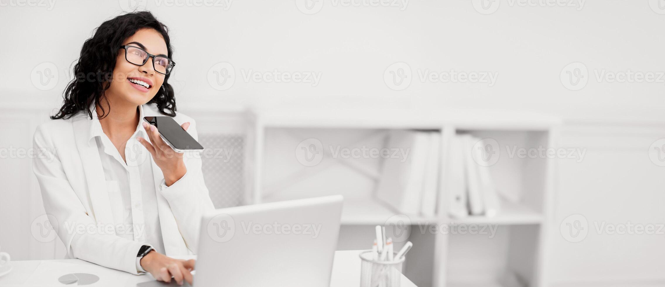 Voice Assistant Concept. Hispanic manager recording message using mobile phone. Free space photo