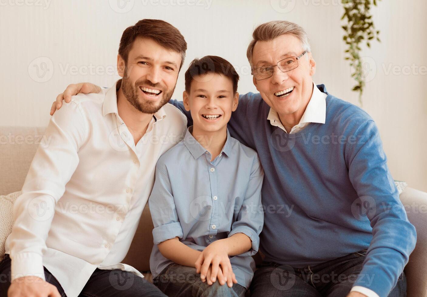Joyful Grandpa With Mature Son And Little Grandson Smiling At Camera Posing Sitting On Couch Indoor. Male Generation Concept. photo