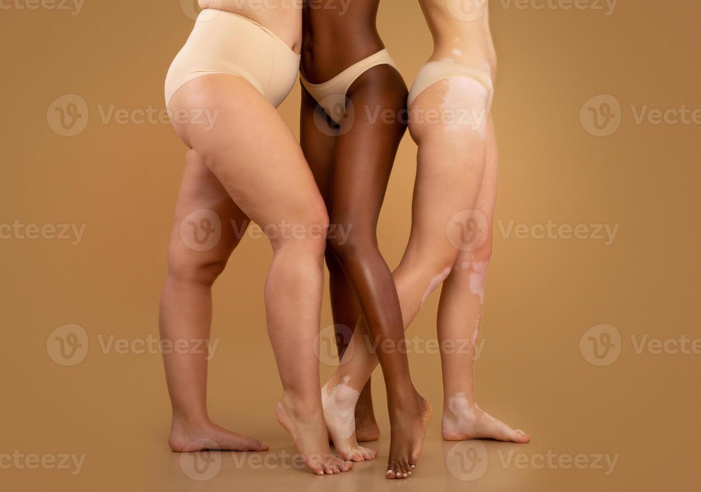 Every Body Is Beautiful. Tree women with different race and body sizes posing in underwear over beige background, cropped image with free space photo