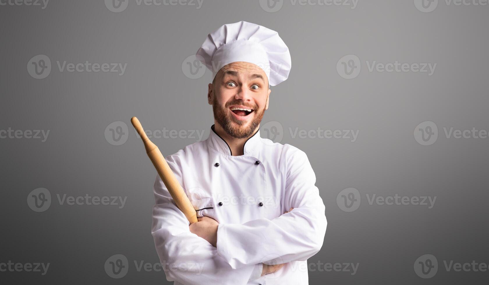 Professinal Baker. Excited Male Chef Holding Rolling Pin For Dough Posing Over Black Studio Background photo
