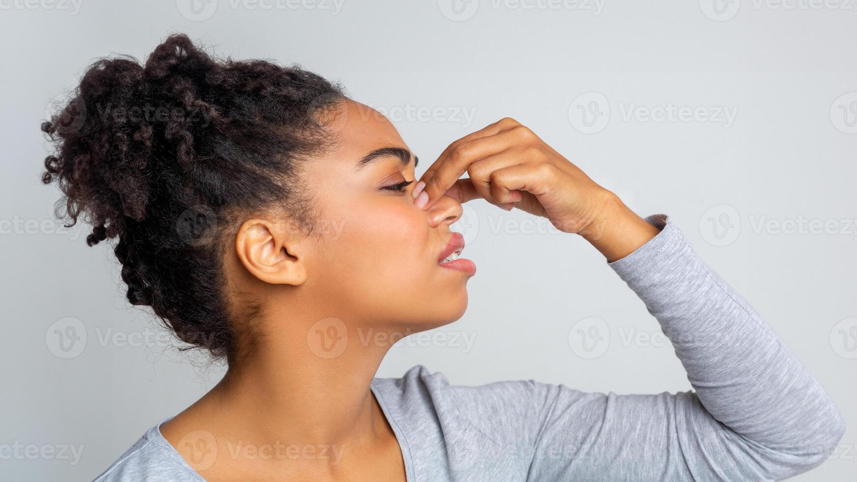 Side view of african young woman touching her nose, suffering from allergic rhinitis photo