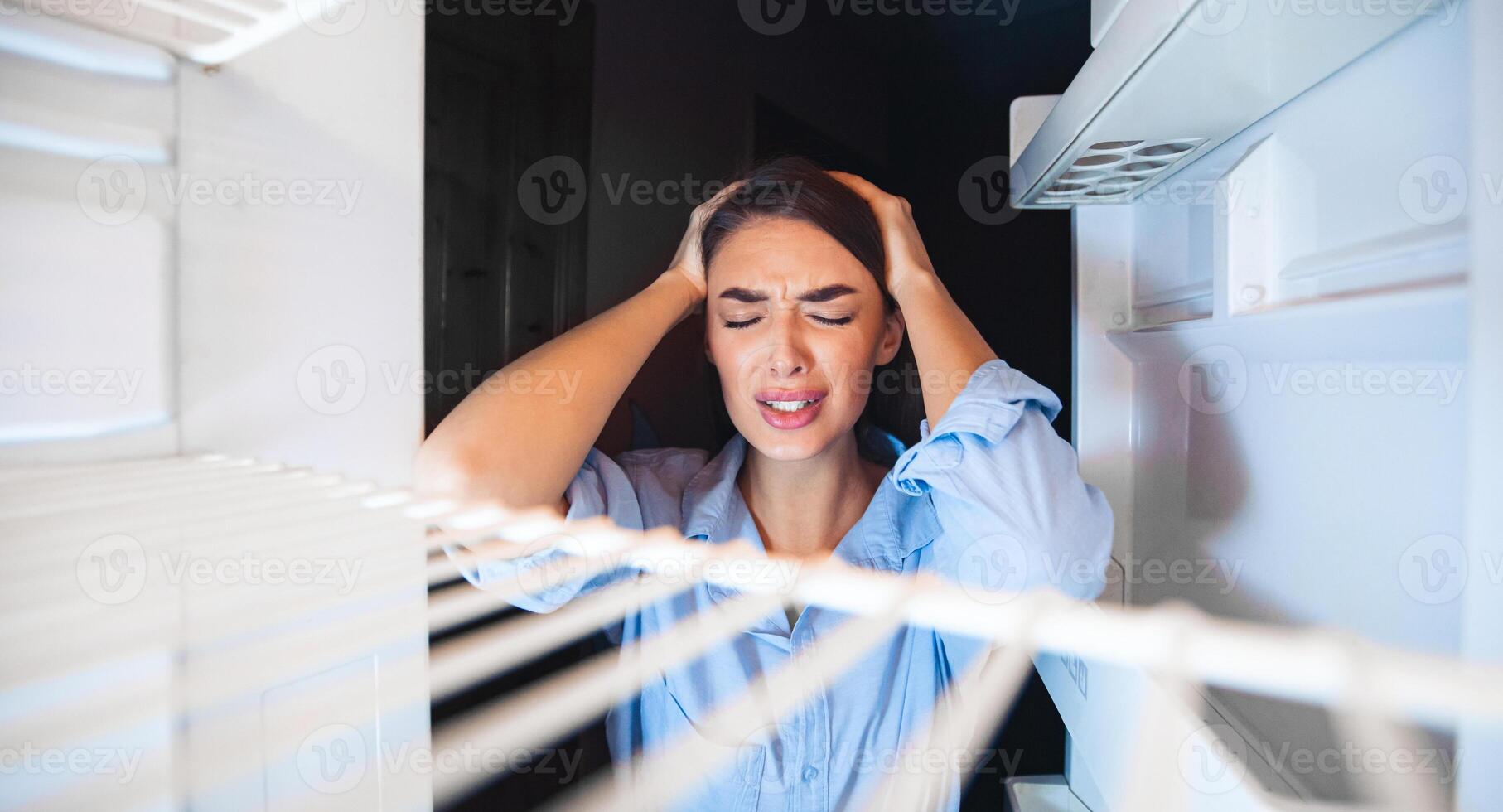 No food at home. Desperate housewife in despair looking at empty fridge, view from inside photo