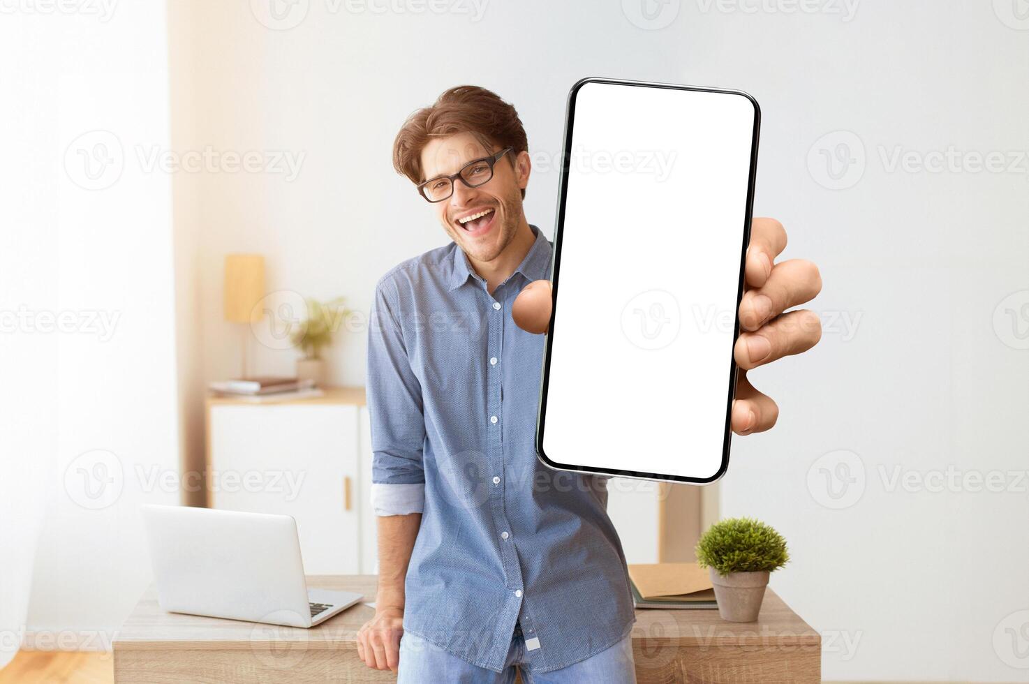 Hey, You. Smiling Man Pointing Finger At Camera Standing Indoors. Free Space For Text photo