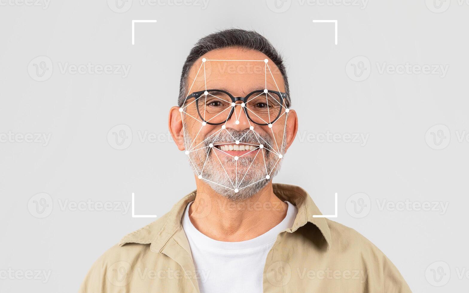 A smiling man wearing glasses stands in a bright studio, showcasing a facial recognition overlay on his face, highlighting modern technology. photo