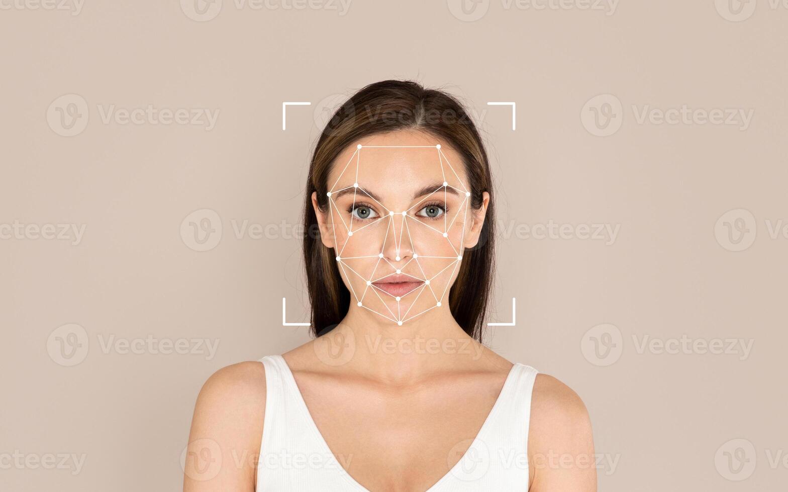 A woman stands calmly as facial recognition technology is applied to analyze her features with a simple background. photo