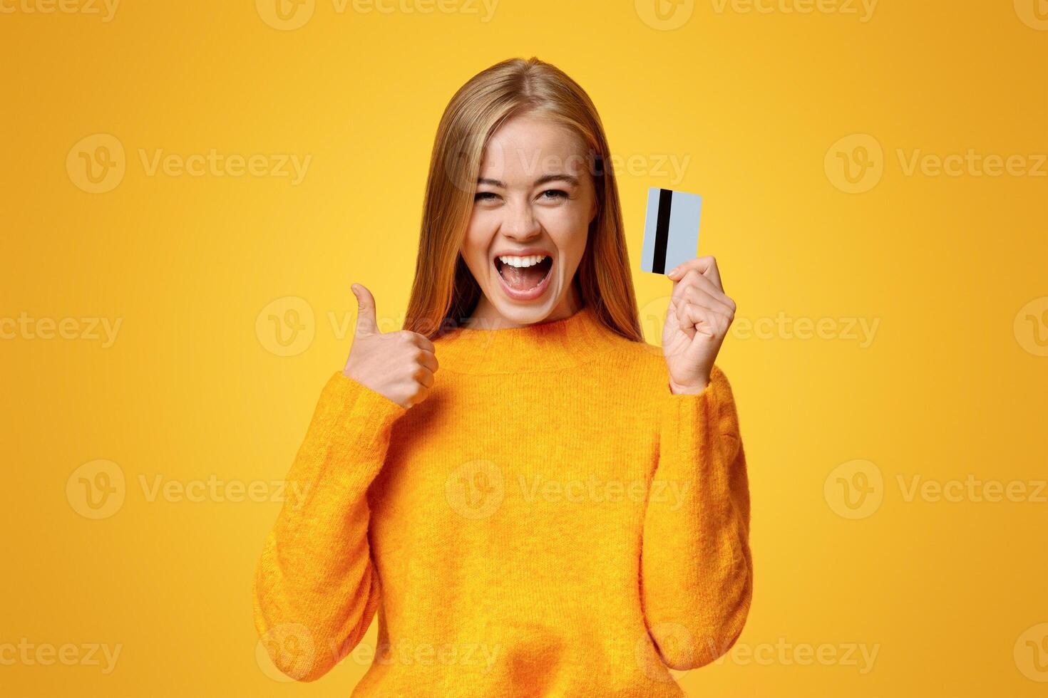 Father's credit card. Carefree young girl showing thumb up, excited about upcoming shopping photo
