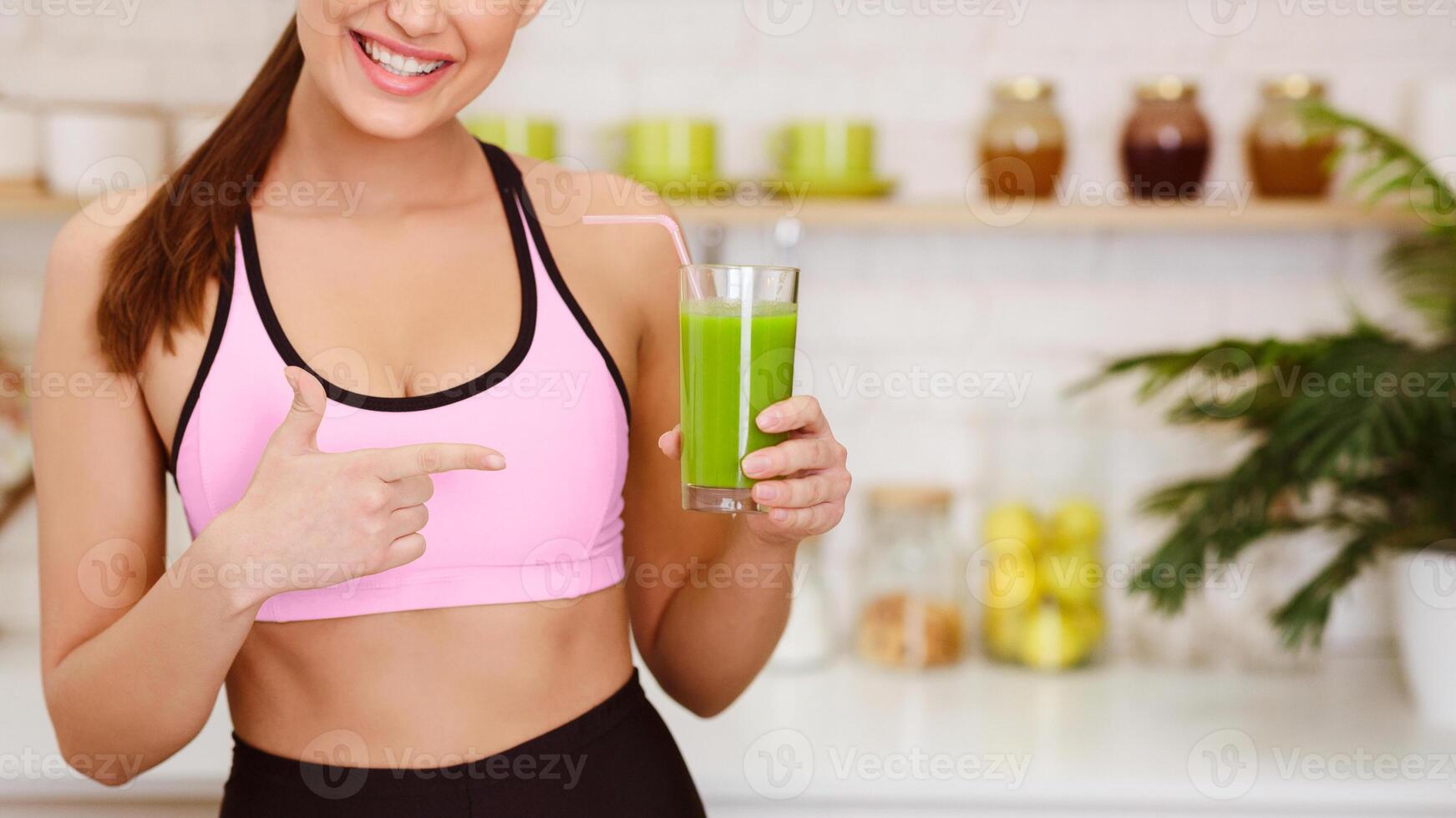 Healthy Smoothie. Sporty Woman Pointing On Detox Juice In Kitchen, Copy Space photo