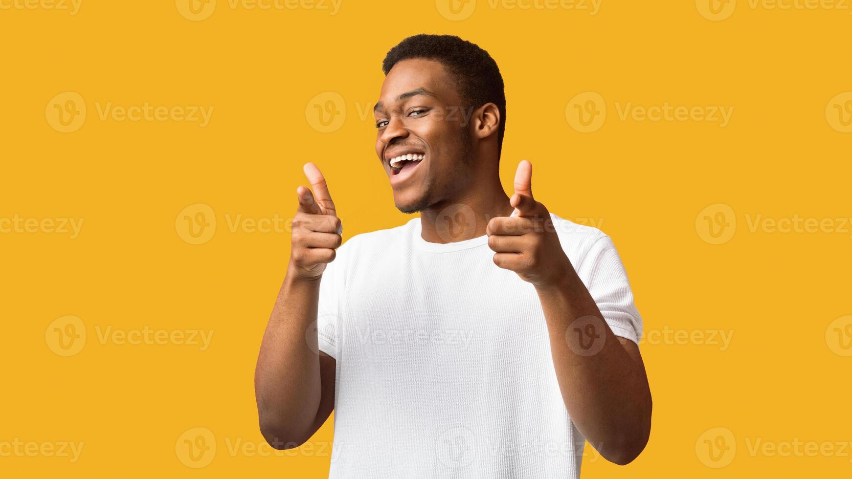 Hey, You. Positive black guy pointing fingers at camera posing over orange background, panorama, copyspace photo