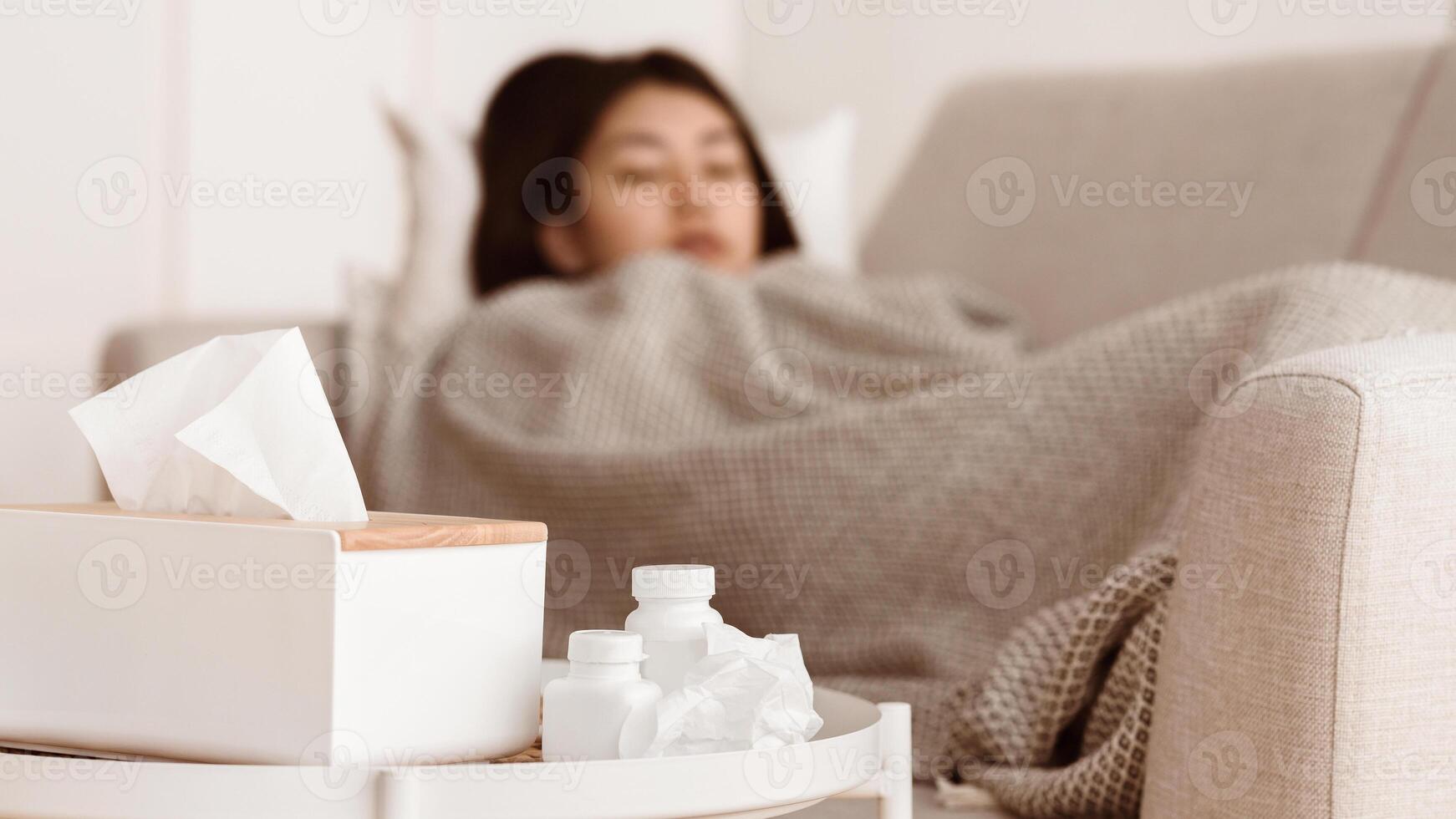 Sick Asian Woman Sleeping with High Fever and Medicine on Foreground photo