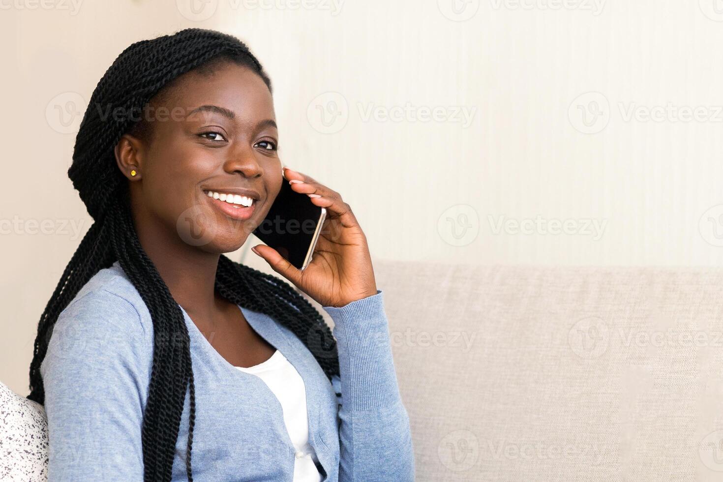 Cheerful Black Woman Talking on Phone, Drinking Morning Coffee And Using Laptop at Home photo