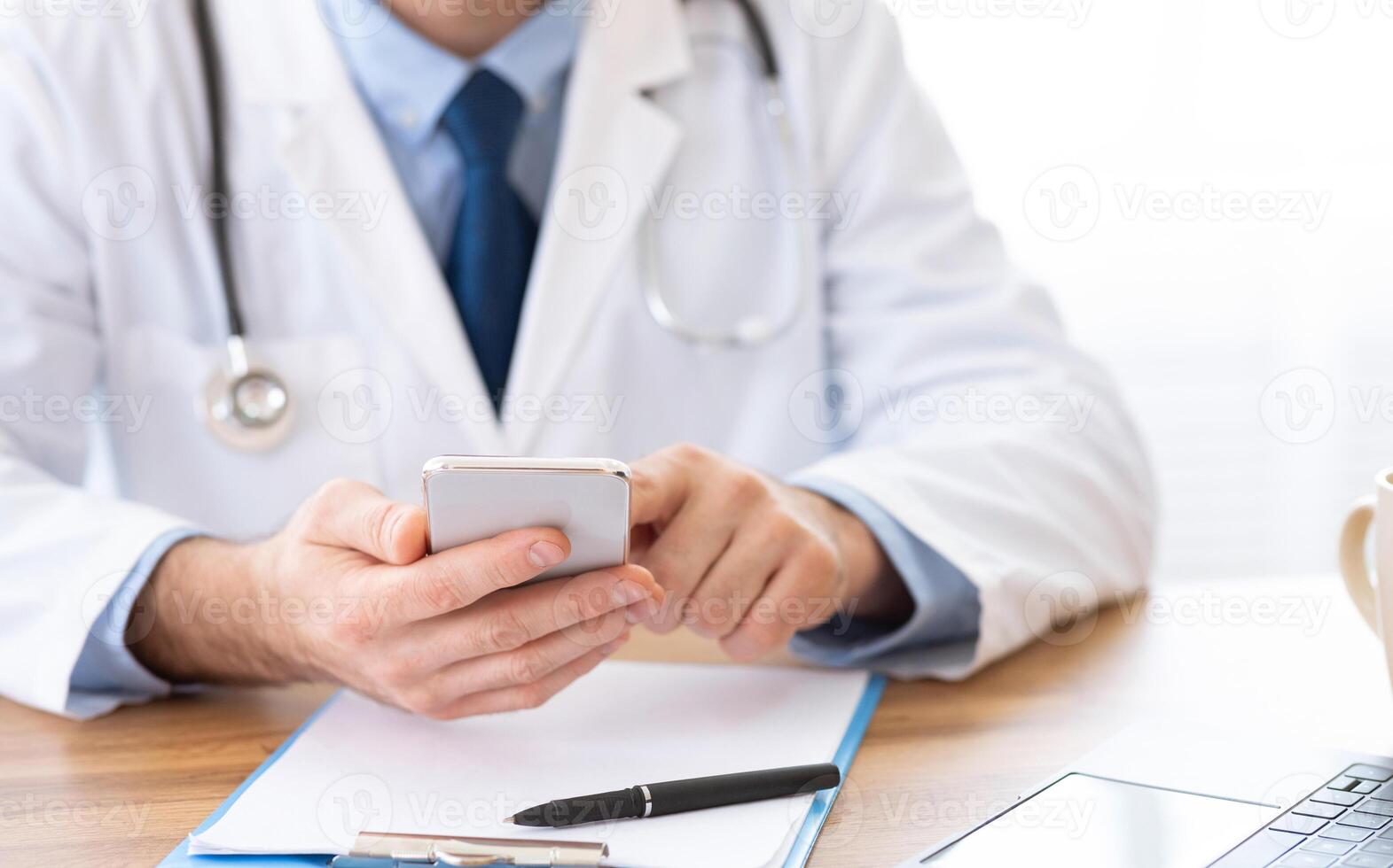 Consultation Online. Unrecognizable doctor using smartphone at workplace, messaging with patient, prescribing treatment photo