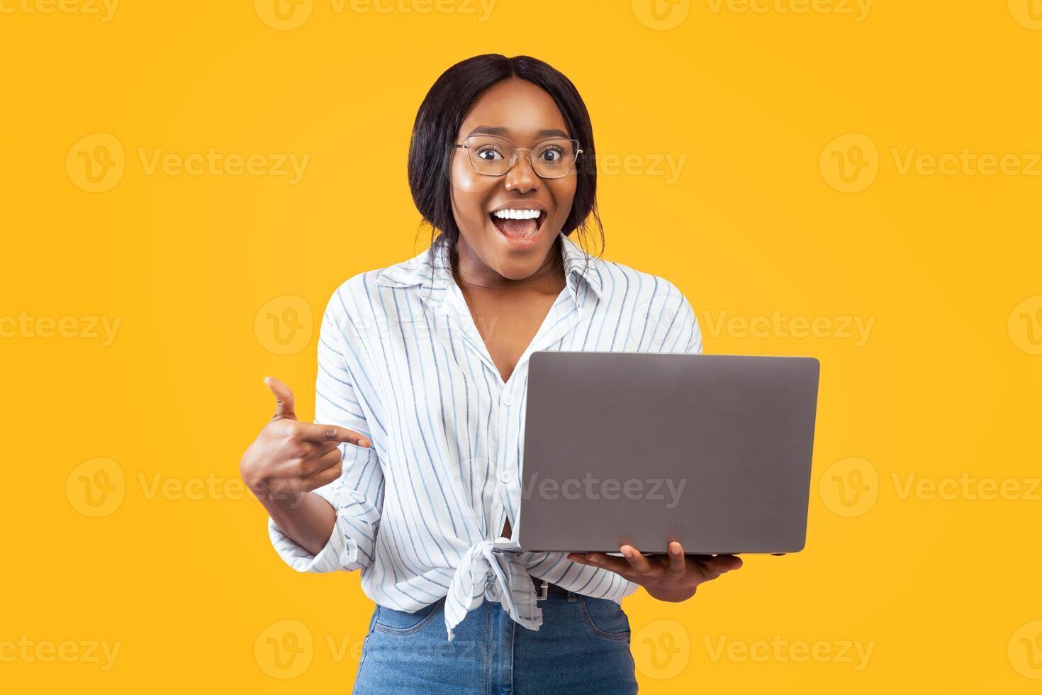 Excited African American Lady Holding Laptop Pointing Finger Recommending Website Standing Over Pink Background. Studio Shot photo