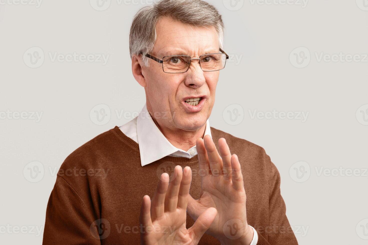 Disgust. Disgusted Senior Man Gesturing No Disapproving Something Posing On Gray Background. Studio Shot photo