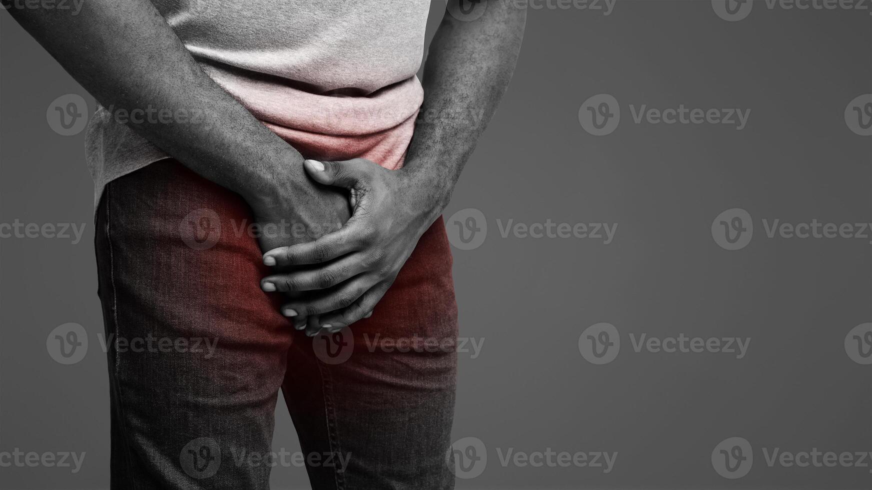 Cropped of black man holding his groin over white background, copy space photo