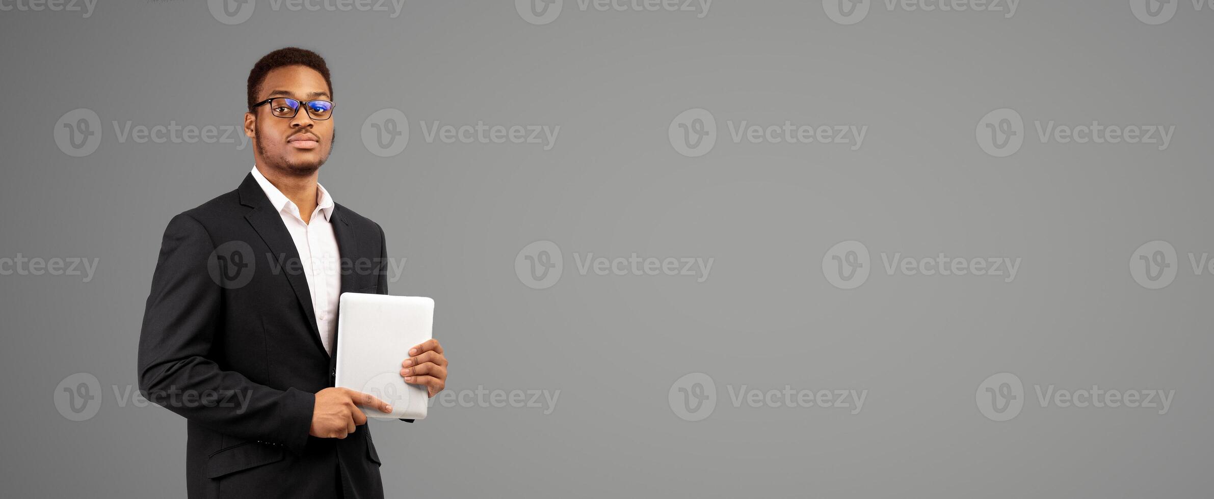 Modern Technologies. Serious afro guy holding tablet isolated over white studio background. Empty space, panorama photo