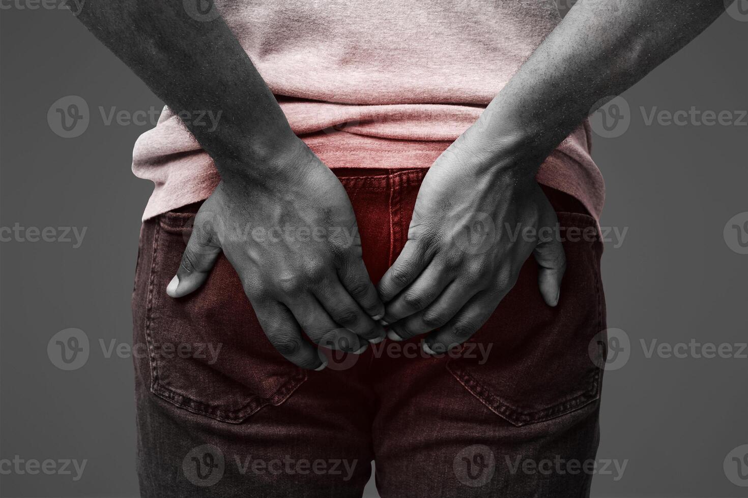 Afro man with hemorrhoids holding his butt in pain, white background, cropped photo