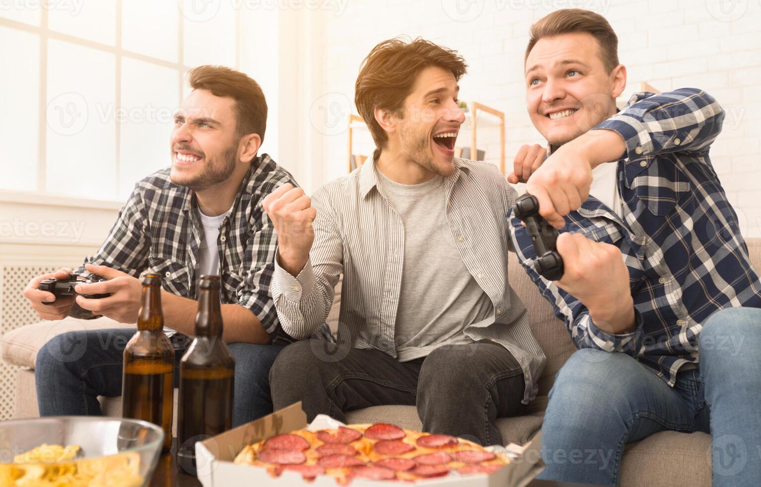 Avid gamers. Excited men playing games, having fun at home photo