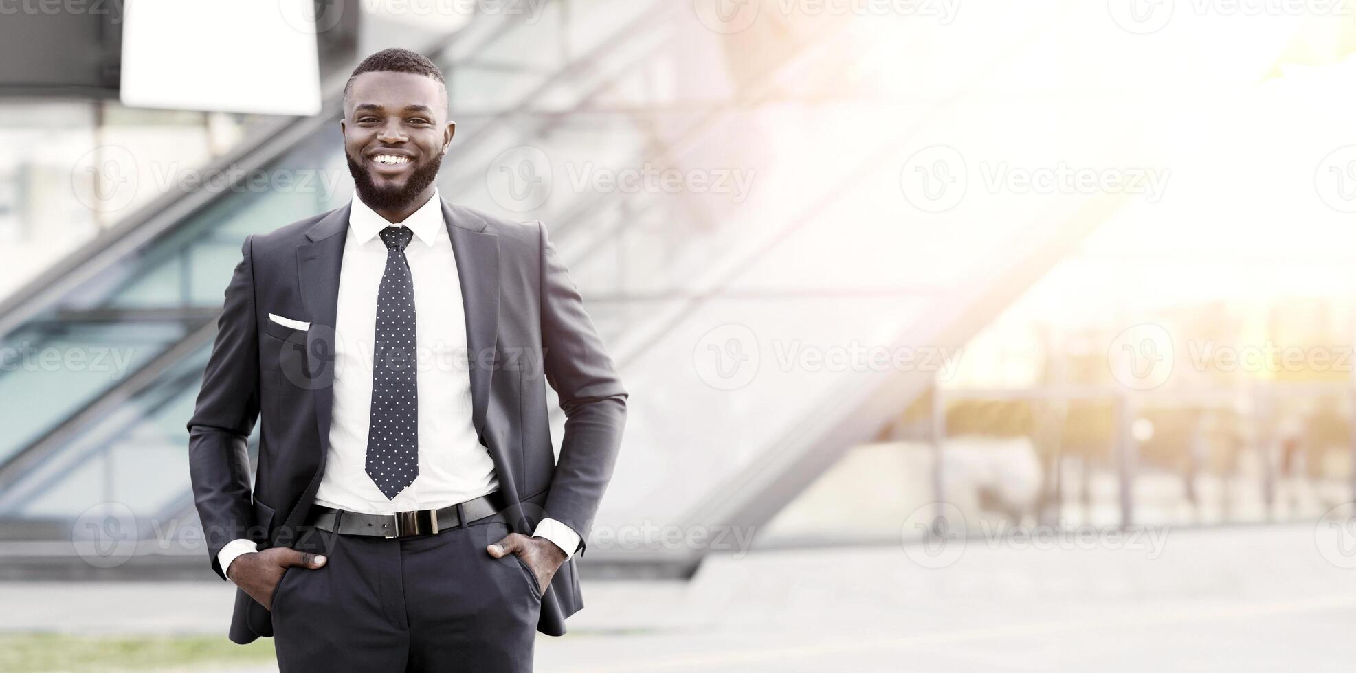 Starting Own Business. Black Businessman Smiling At Camera Outdoor Standing Against Modern Building. Free Space photo