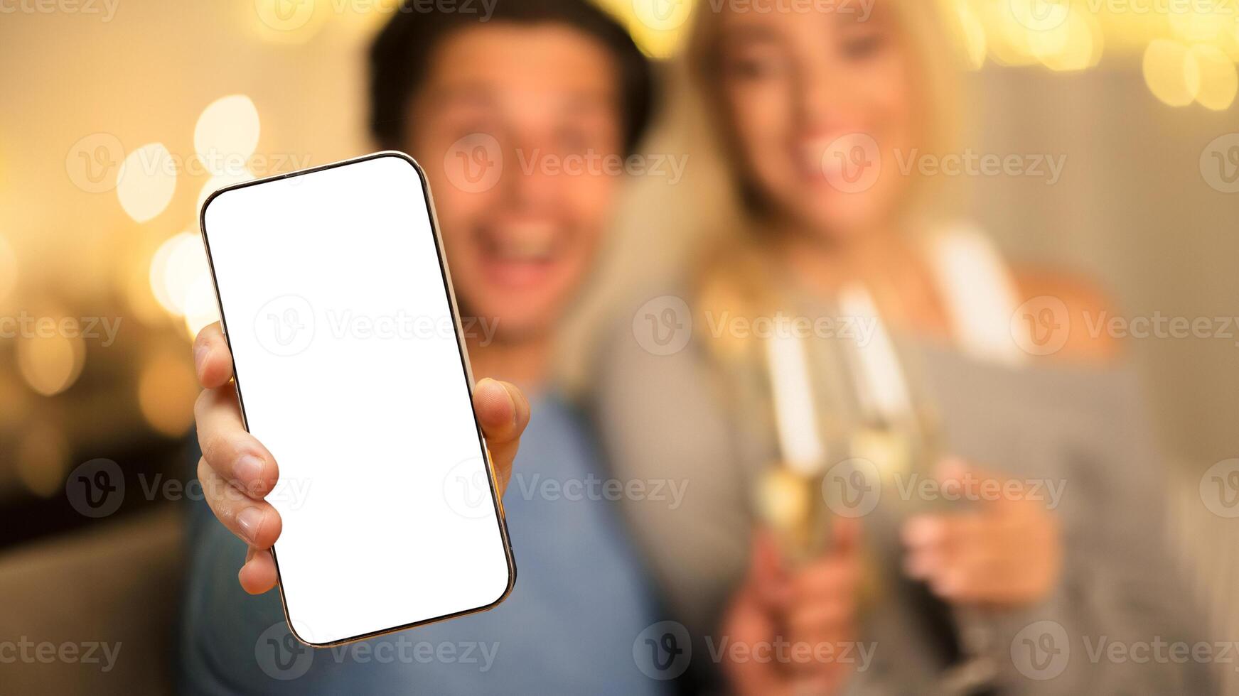 Home selfie. Couple taking photo on phone with blank screen, relaxing at cozy winter evening at home