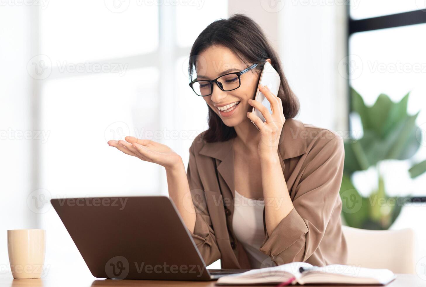 Informal Call. Happy young woman in glasses calling her friend, talking and asking about something, using laptop photo