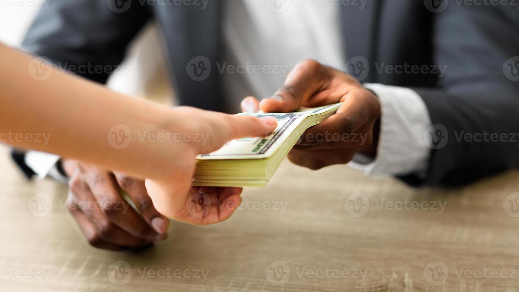 Business bribery and corruption. Unrecognizable black businessman accepting bribe from his client, sealing the deal photo