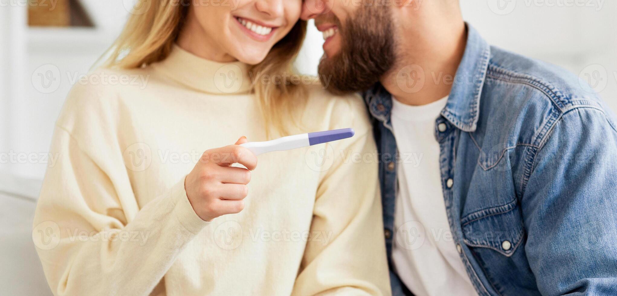 A man and a woman smiling as they hold a toothbrush. photo