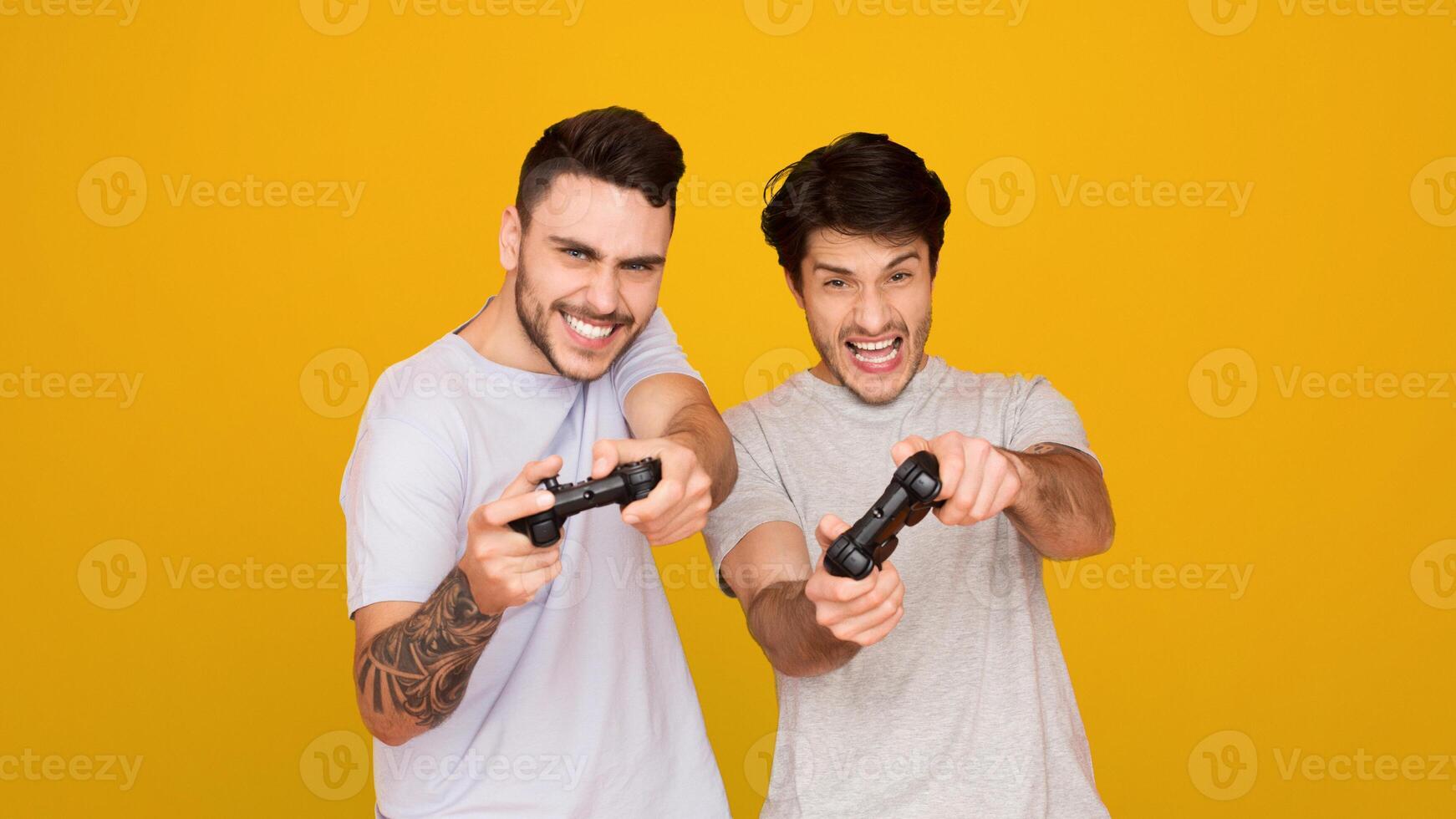 Two european guys deeply engaged in playing games together, their faces showing focus and enjoyment photo