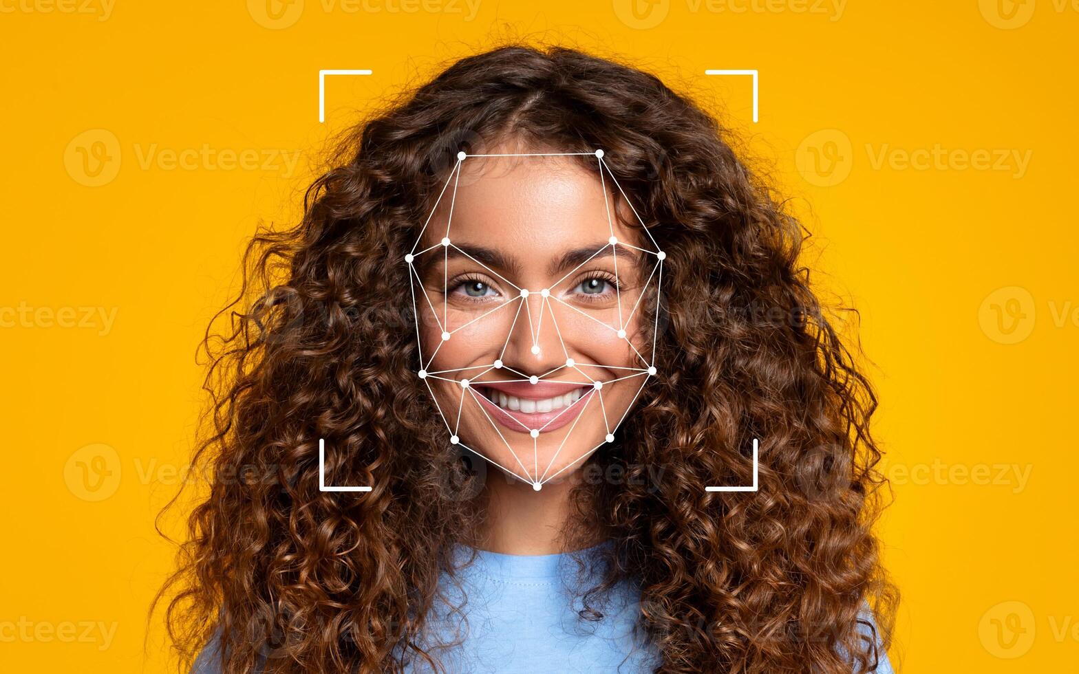 A woman with curly hair smiles brightly as a facial recognition overlay appears on her face against a vibrant yellow background. photo