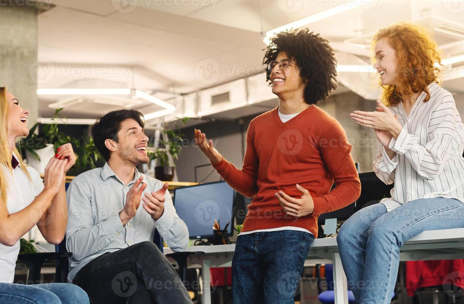 Cheerful business team greeting their colleague, applauding to successful black guy, free space photo