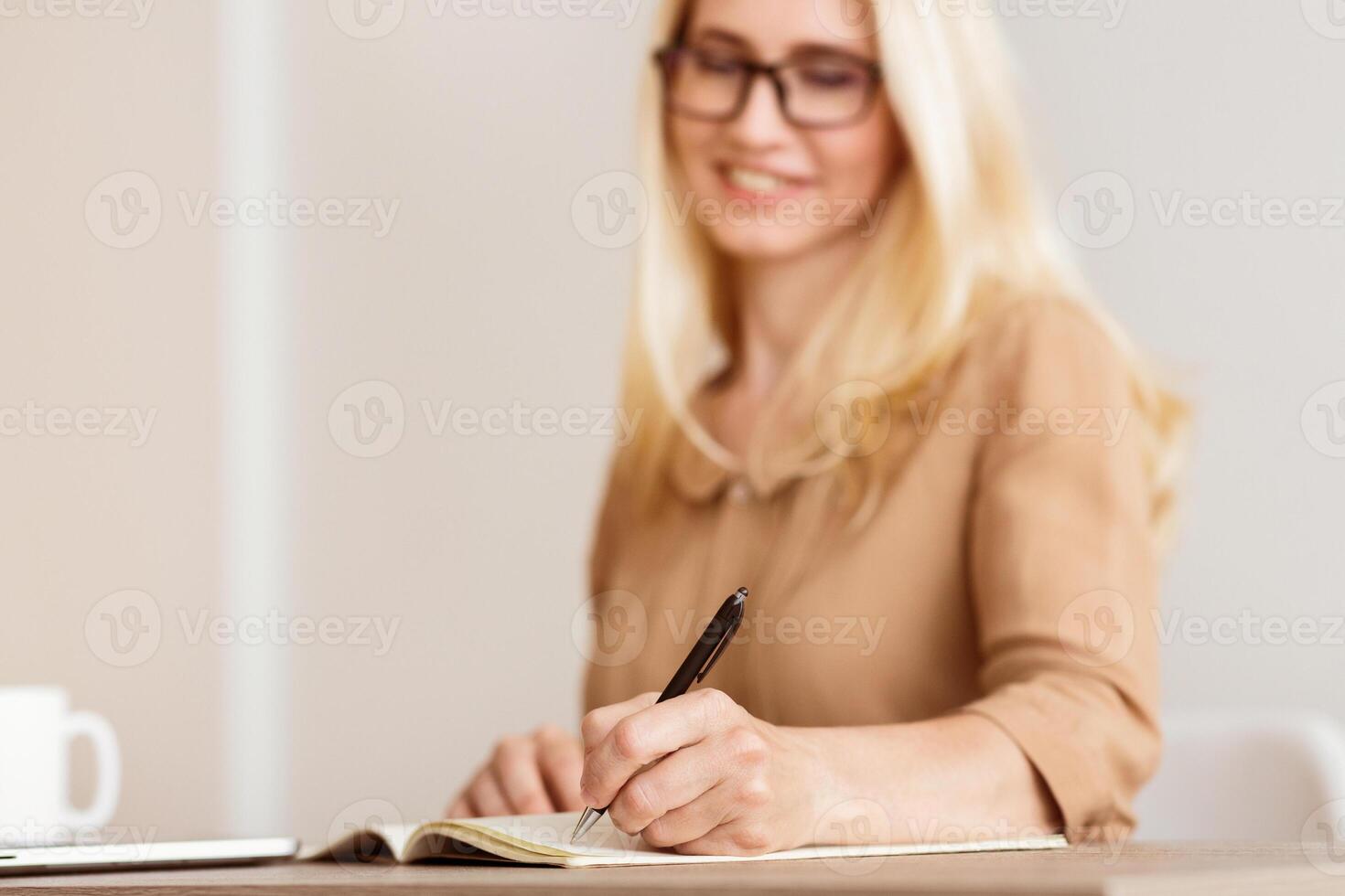 Mature Freelancer Writing Down Plans Project Into Notebook, Focus On Hand photo