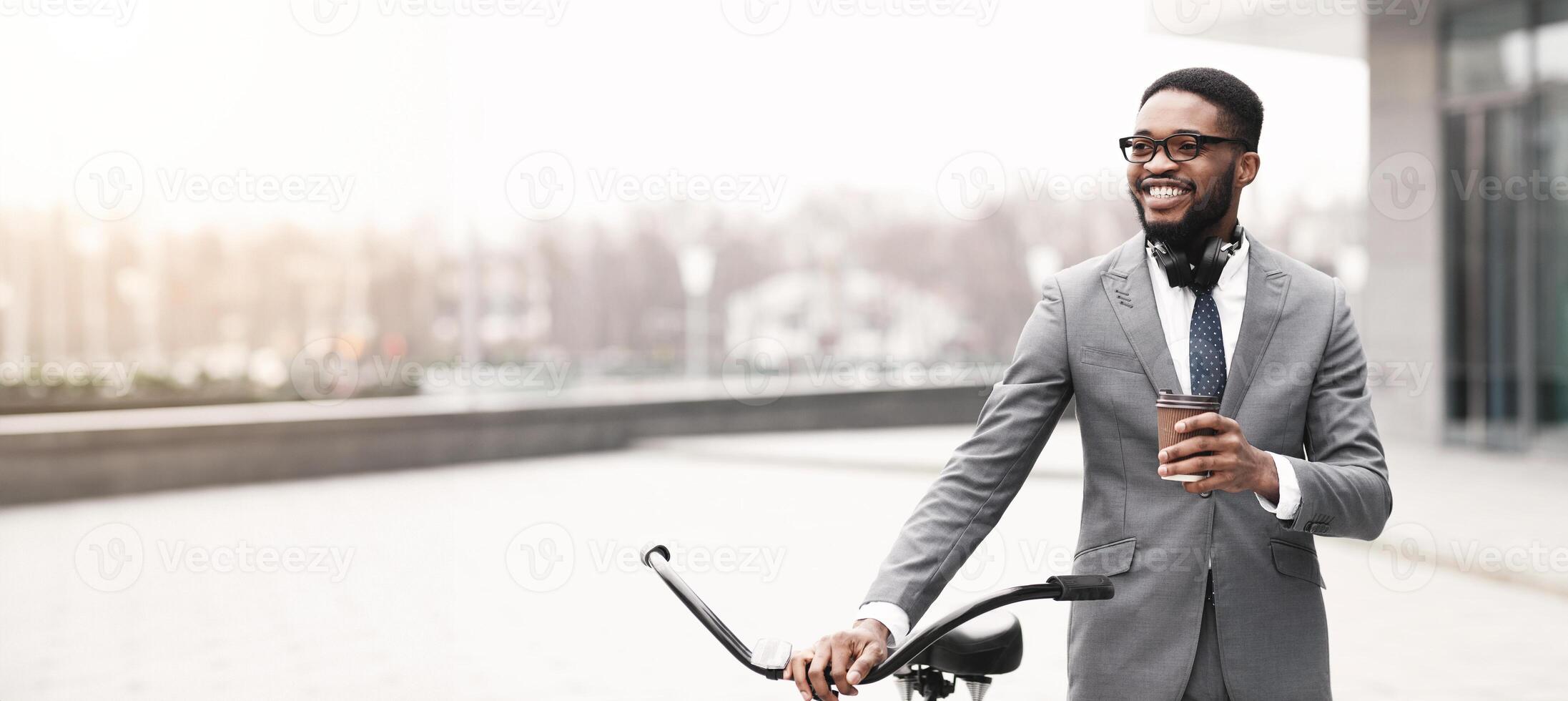Black man is on his bike in the city, focused on his phone. The mood is dynamic and professional, reflecting the multitasking lifestyle of a modern urban professional. photo