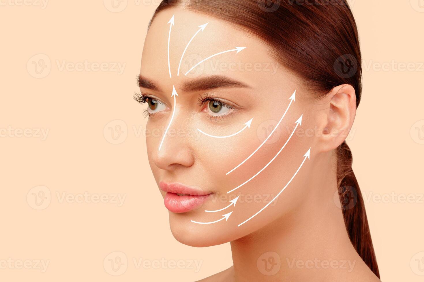 European Lady's Face With Arrows On Smooth Skin Showing Lines Of Facial Lifting And Massage Over White Studio Background, Looking Aside. Rejuvenation Skincare And Plastic Surgery Concept photo
