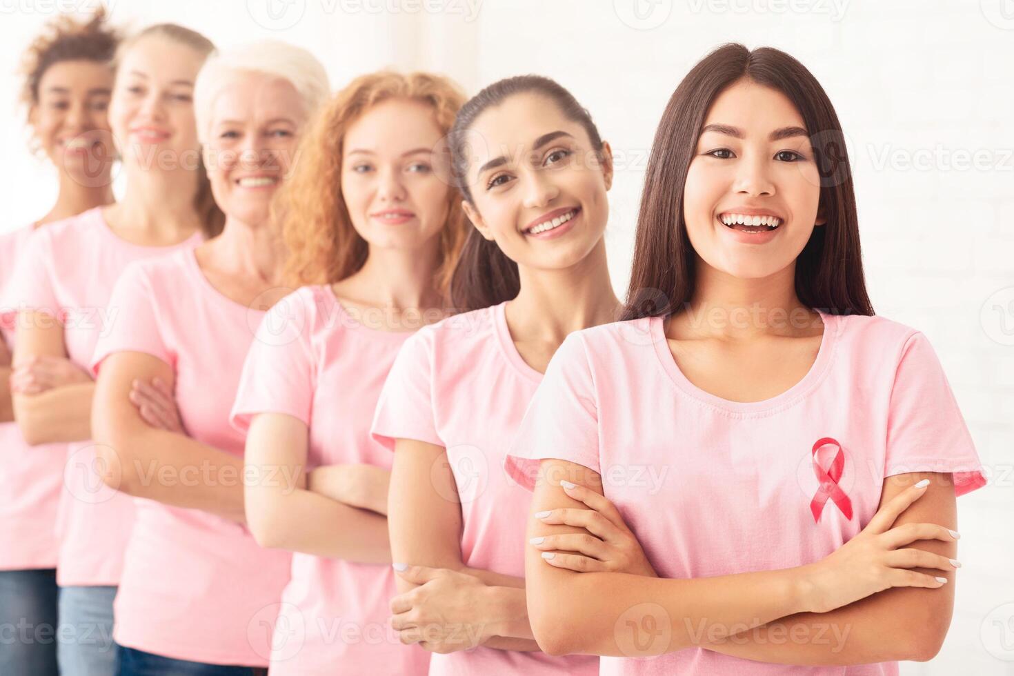 United Breast Cancer Volunteers Ladies Standing In Line Supporting Oncology Awareness Campaign On White Background. Shallow Depth photo