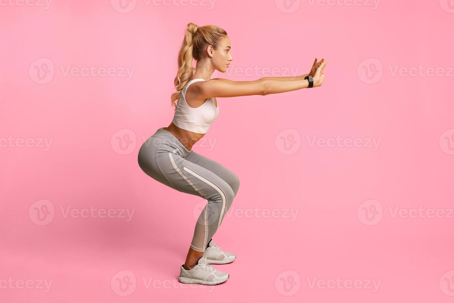 Workout And Fitness. Girl Doing Deep Squat Exercise Over Yellow Studio Background. Copy Space, Side View photo