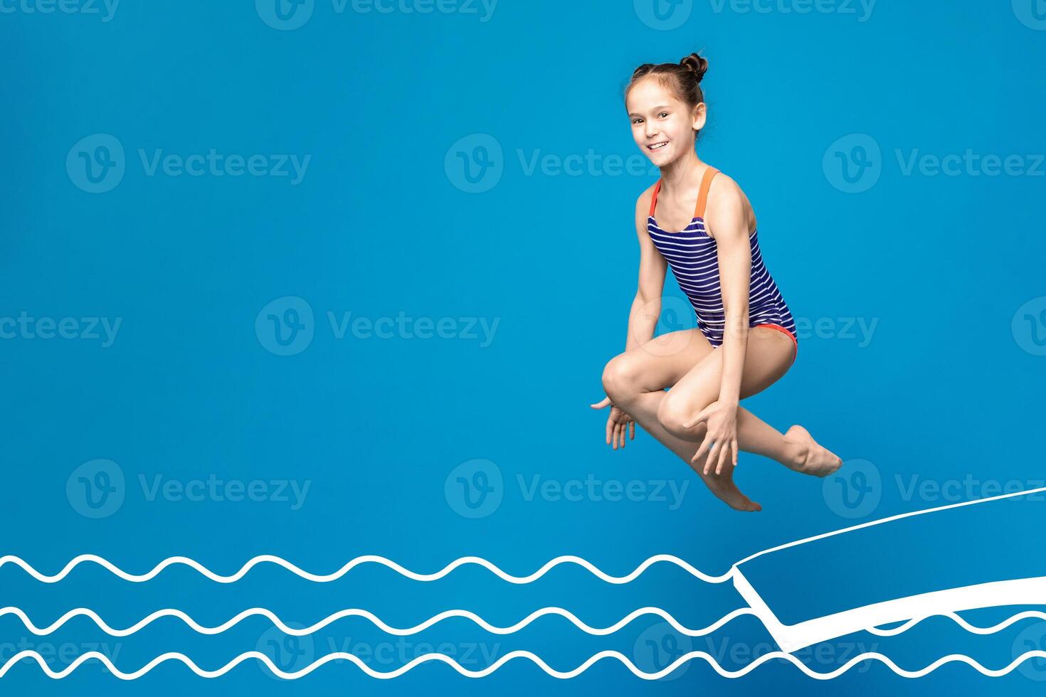 A young girl, wearing a blue and white striped swimsuit, is captured mid-air as she jumps over an illustrated pool. The background is a vibrant blue, copy space photo