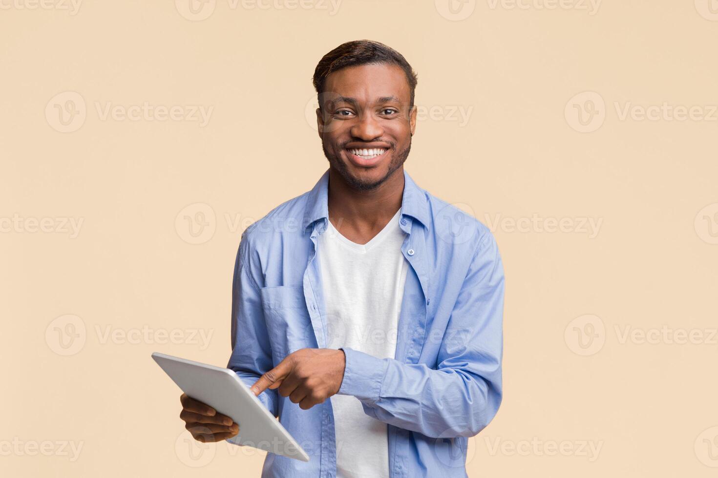 Great Application. Smiling African American Guy Using Digital Tablet Standing Over Yellow Background. Studio Shot photo