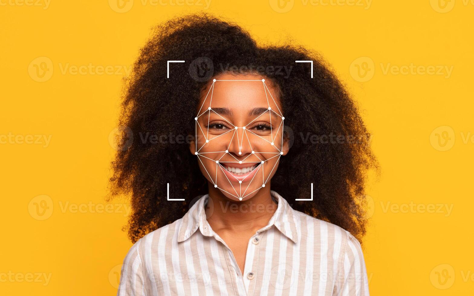 A cheerful African American woman with curly hair smiles broadly against a vibrant yellow backdrop, showcasing her joyful expression. photo