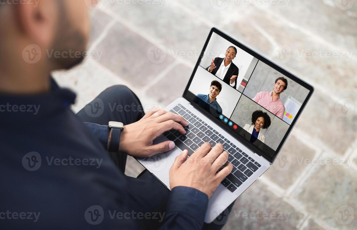 A person participates in a virtual meeting with four colleagues displayed on a laptop screen, highlighting remote work collaboration and communication. photo
