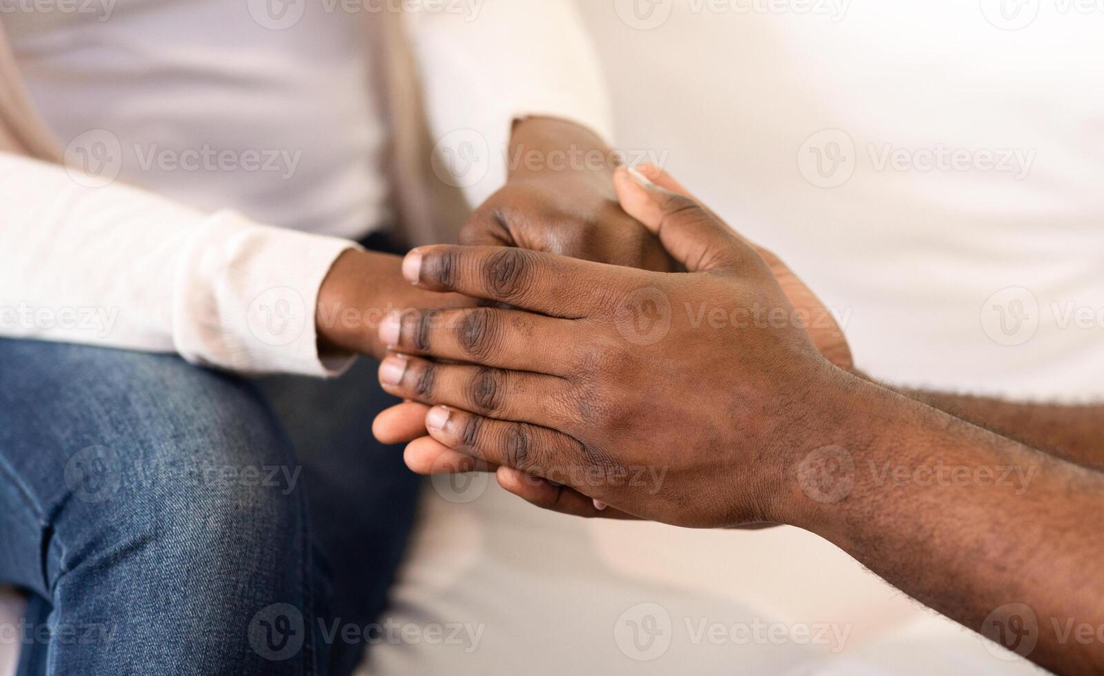 A close-up image of two hands clasped together, showing the intimacy and connection between the individuals. photo