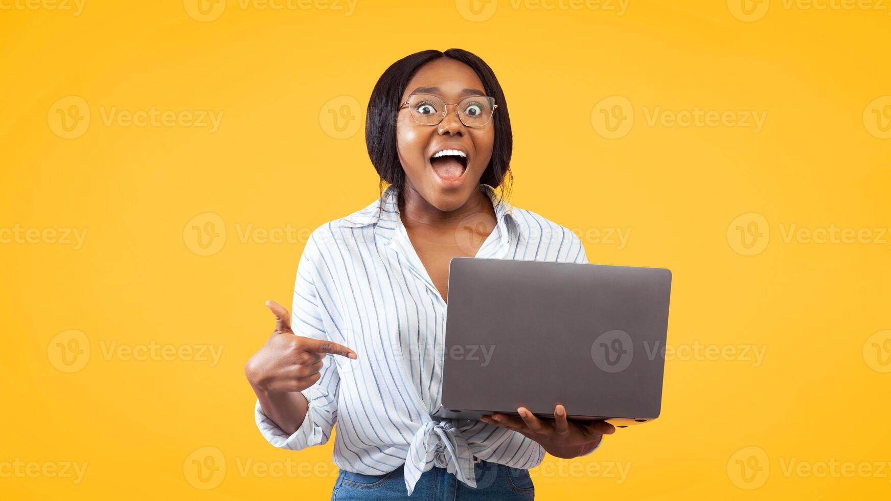 Excited Afro Girl Pointing Finger At Laptop Standing Over Pink Studio Background. Check This Out. Panorama photo