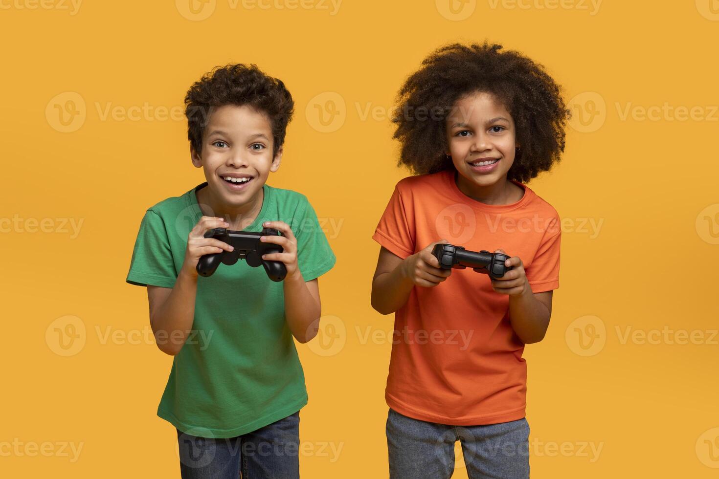 Two African American boys, both holding game controllers in their hands, seem engrossed in an intense gaming session. Their faces show concentration and excitement as they focus on the screen. photo