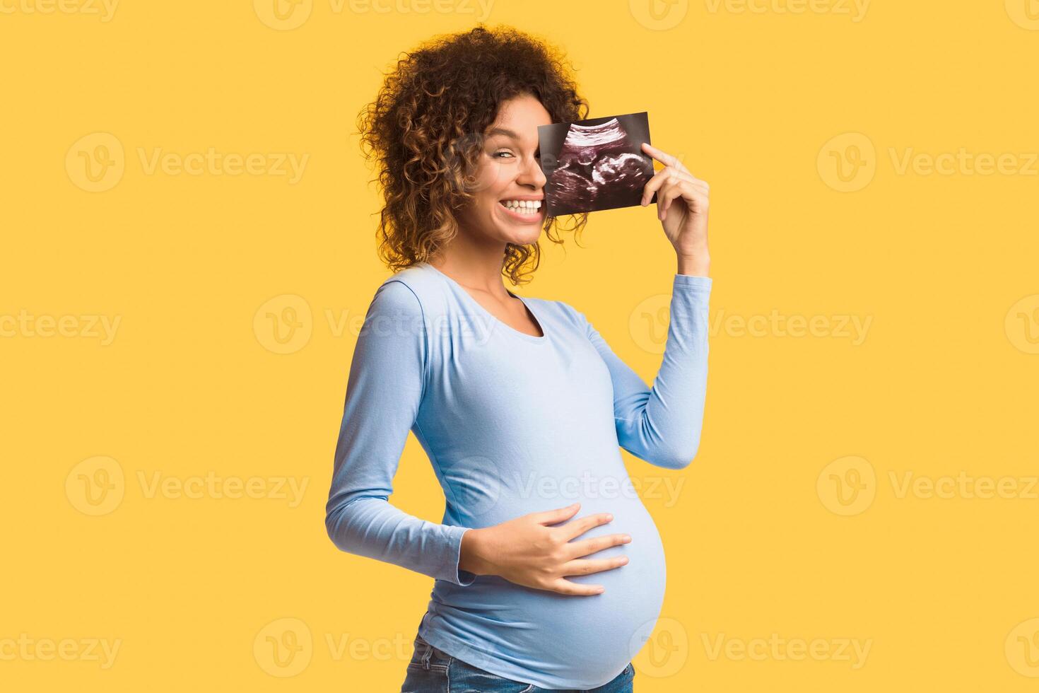 Happy pregnant woman enjoying photo of her unborn child, anticipating her future life, white background
