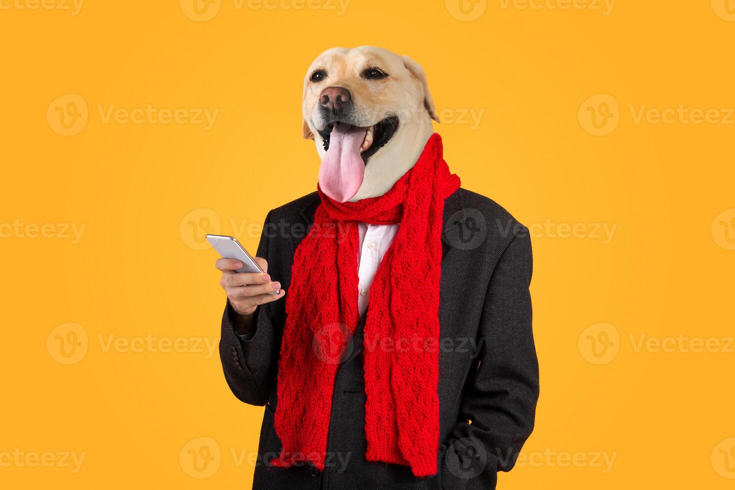 A dog wearing a suit and a vibrant red scarf stands proudly while holding a smartphone. The dog's expression is joyful, and the bright yellow background adds a playful touch to the overall mood. photo