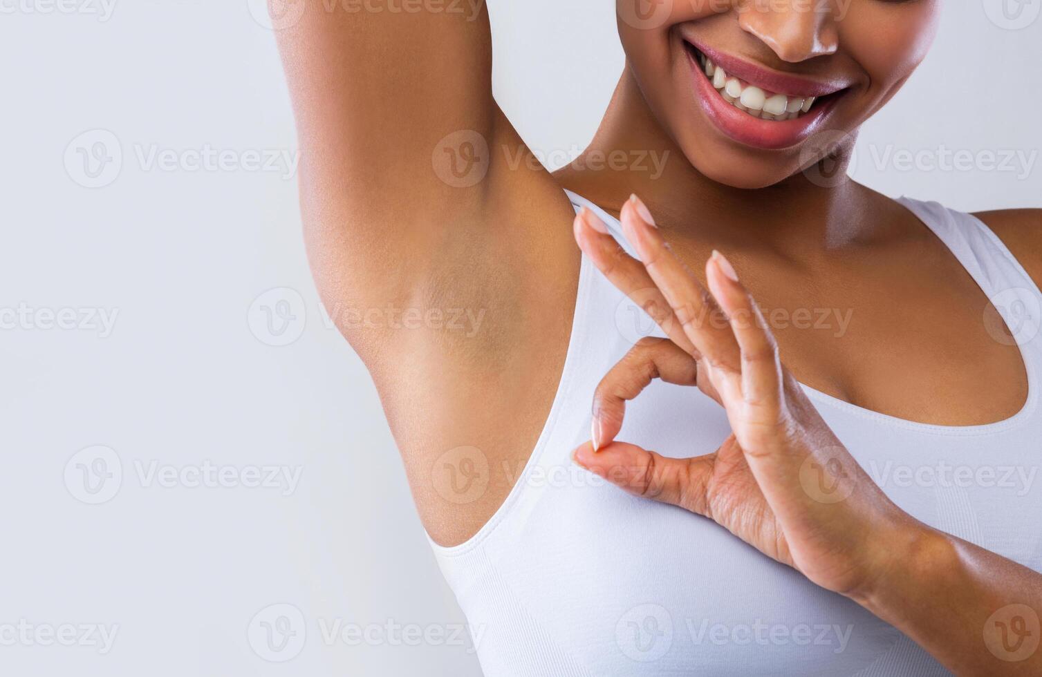 Cropped of black woman looking at shaved armpit, showing okay gesture over grey background photo